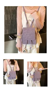 Detail view of purple matte backpack with drawstring flap and cute bear charm pendant
