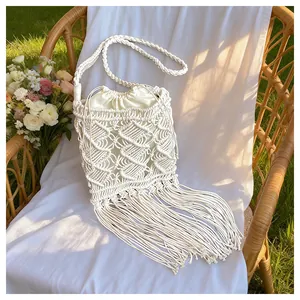 Detail of bohemian macramé woven bag featuring long tassels and a drawstring inner pouch