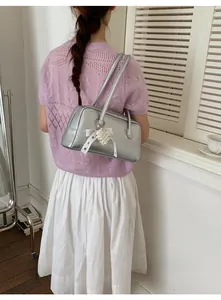 Sac à bandoulière argenté avec nœud en dentelle blanche et charm cœur en perles