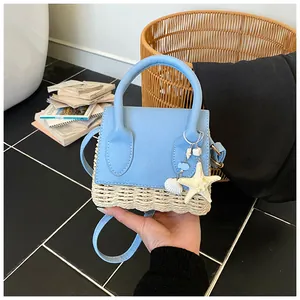 Detail of mini straw woven bag with light blue leather trim and ocean charms