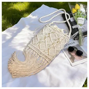 Close-up of bohemian macrame straw bag with tassel details and woven texture