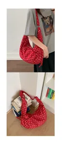 Detail of red polka dot canvas hobo bag with adjustable strap and side drawstring accent