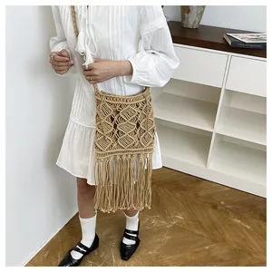 Detailed close-up of handmade straw bag with woven pattern and long tassels on the side