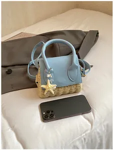 Detail of mini straw woven handbag in light blue leather featuring a starfish charm