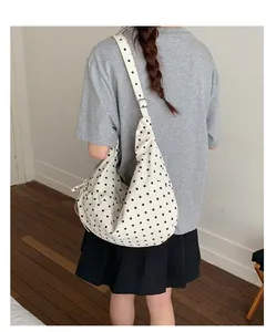 Polka dot hobo bag with adjustable strap shown on shoulder for daily commute