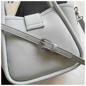 Detail view of light blue lychee pattern leather bucket bag with silver metal buckle