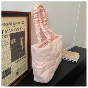 Detail of light pink quilted tote bag with unique ruched straps for daily commuting