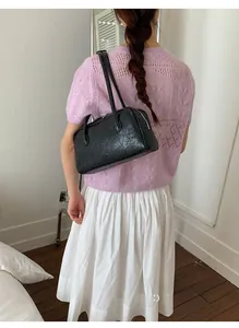 Détail d'un sac Boston en cuir plissé noir doté de fines doubles bandoulières élégantes