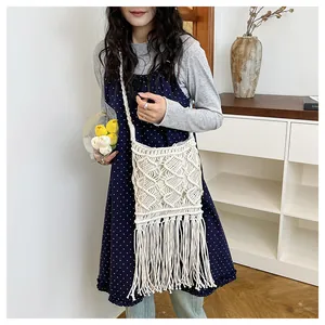 Detail of bohemian cotton straw bag featuring diamond weave and long fringe tassels