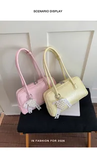 Détail de sacs roses et jaunes avec breloques cœur en perles et nœuds décoratifs en dentelle