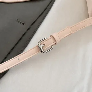 Detalle de la correa ajustable de cuero rosa claro con hebilla metálica plateada
