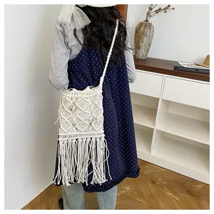 Detail view of handmade bohemian woven cotton shoulder bag with long fringe and tassels