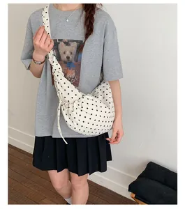 Close-up of polka dot canvas underarm bag showing side drawstring detail and fabric texture