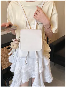 White minimalist backpack with drawstring closure and cute plush bear charm detail