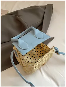 Detailed top view of mini straw bag showing light blue flap and yellow polka dot lining