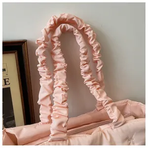 Detailed shot of pink nylon tote bag featuring scrunchie style handles and bow detail