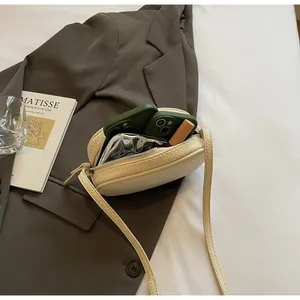 Detailed interior view of the beige lychee leather crossbody bag showing phone storage space