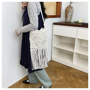 Detail of bohemian white hand-woven cotton shoulder bag with long fringe tassels