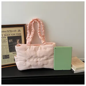 Detail of light pink quilted tote bag with Gugugaga embroidery and ruched handle design