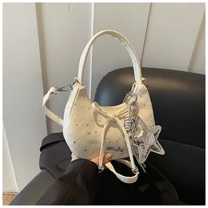 Detail van de crème canvas tas met zilveren sterrenprint en een hanger van lovertjes