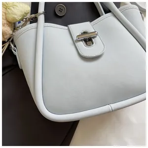 Detail view of light blue lychee pattern bucket bag with silver lock and heart charm
