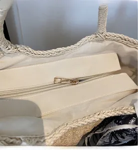 Detail of smooth metal zipper and premium fabric lining inside the woven straw tote bag