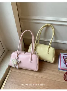 Détail de sacs sous le bras roses et jaunes avec charm cœur en perle et grain cuir