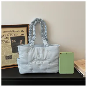 Detail view of light blue quilted tote bag with embroidered bow and large capacity
