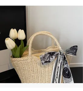 Close-up of beige woven tote bag with wavy rim, braided handle, and floral France scarf