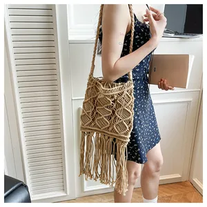 Detail of bohemian macramé shoulder bag with diamond weave pattern and long fringe tassels