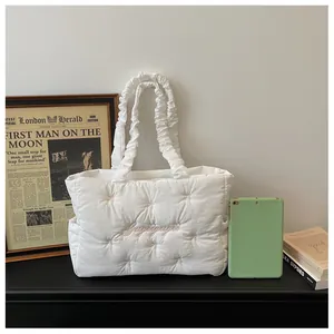 Detail of white quilted nylon tote bag with pink bow embroidery and ruffled shoulder straps