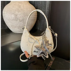 Detail van witte hobo-tas met sterpatroon en zilveren ster- en ballonhondhangers