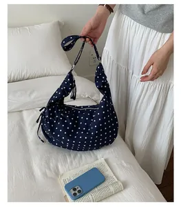 Detailed view of navy blue polka dot canvas shoulder bag with drawstring side detail