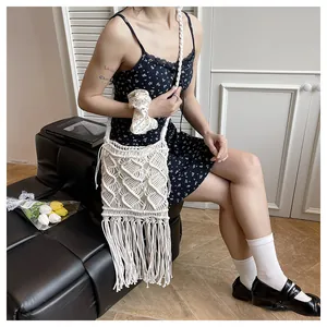 Detail of bohemian macrame straw bag with diamond pattern and long flowing tassels