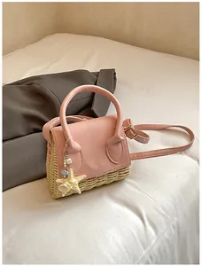 Close-up of pink leather and straw mini bag with starfish shell charm and strap