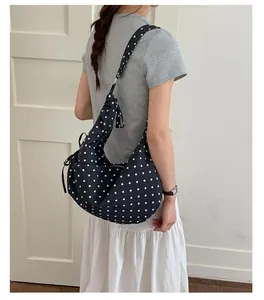 Polka dot underarm bag with drawstring detail shown on a model for daily commute style