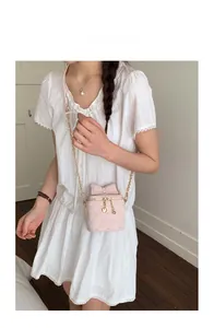 Détail du sac bandoulière matelassé rose avec broderie cœur et chaîne dorée