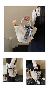 Detail of woven straw tote bag with a Paris print silk scarf and tulip decoration