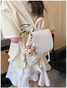 Minimalist white PU leather backpack with a cute brown puppy plush keychain for women