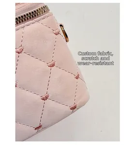 Détail du sac matelassé rose montrant la broderie cœur et la fermeture éclair dorée