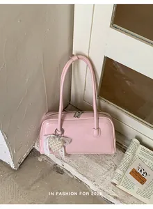 Détail du sac sous le bras rose avec pendentif cœur en perles et nœud en dentelle élégant