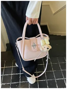 Pink lychee texture bucket bag with cute dog pendant and silver twist lock detail