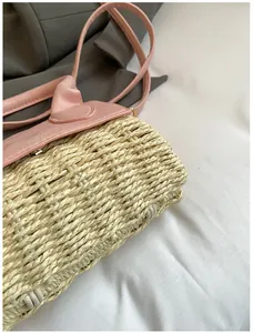 Close-up of woven straw texture and pink leather flap on a stylish crossbody mini bag