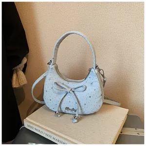 Detail van de lichtblauwe maanvormige crossbodytas met zilveren sterren en strik