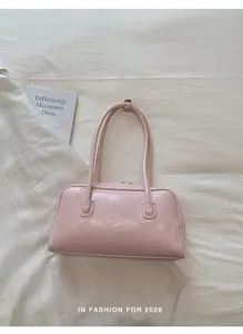 Détail de la texture froncée du similicuir rose clair sur le sac à bandoulière