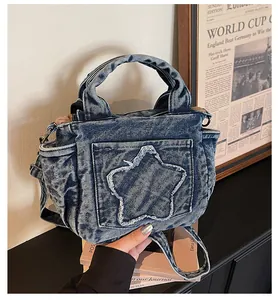 Close-up of light blue denim tote bag featuring a frayed star patch and side pockets