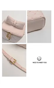 Détail de la trousse rose matelassée avec broderie cœur et fermetures éclair dorées