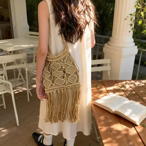 Bohemian khaki woven straw shoulder bag with long tassels and geometric hollow patterns