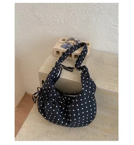 Detailed macro shot of polka dot hobo bag with zipper closure on stone steps
