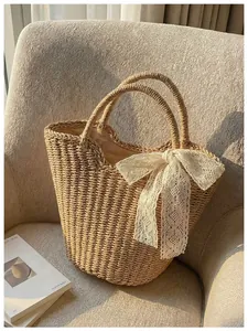 Detailed macro of woven straw tote bag featuring a decorative white lace bow accent